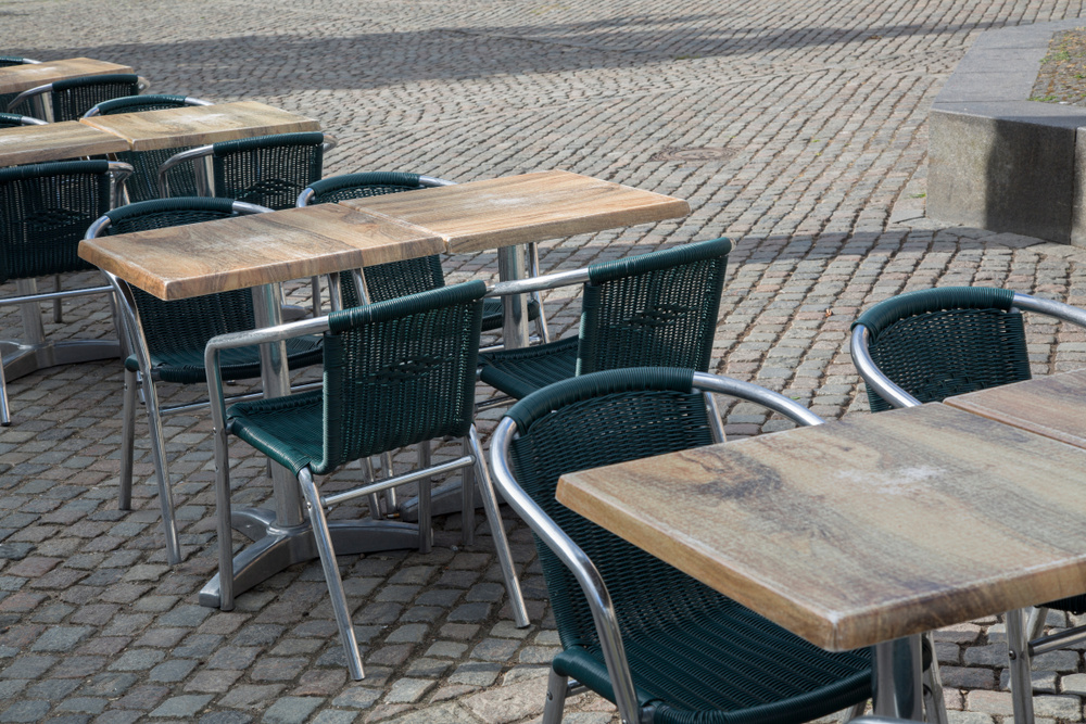 Empty cafe tables and chairs arranged neatly in an inviting outdoor setting.