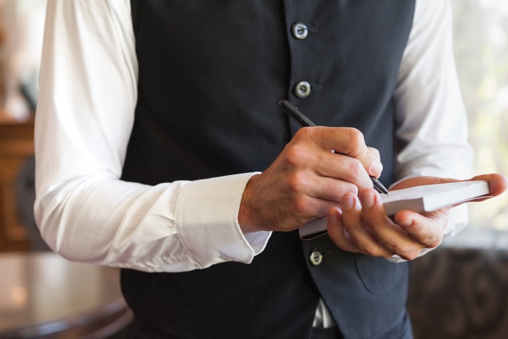 Waiter writing down the order of the customer in the restaurant