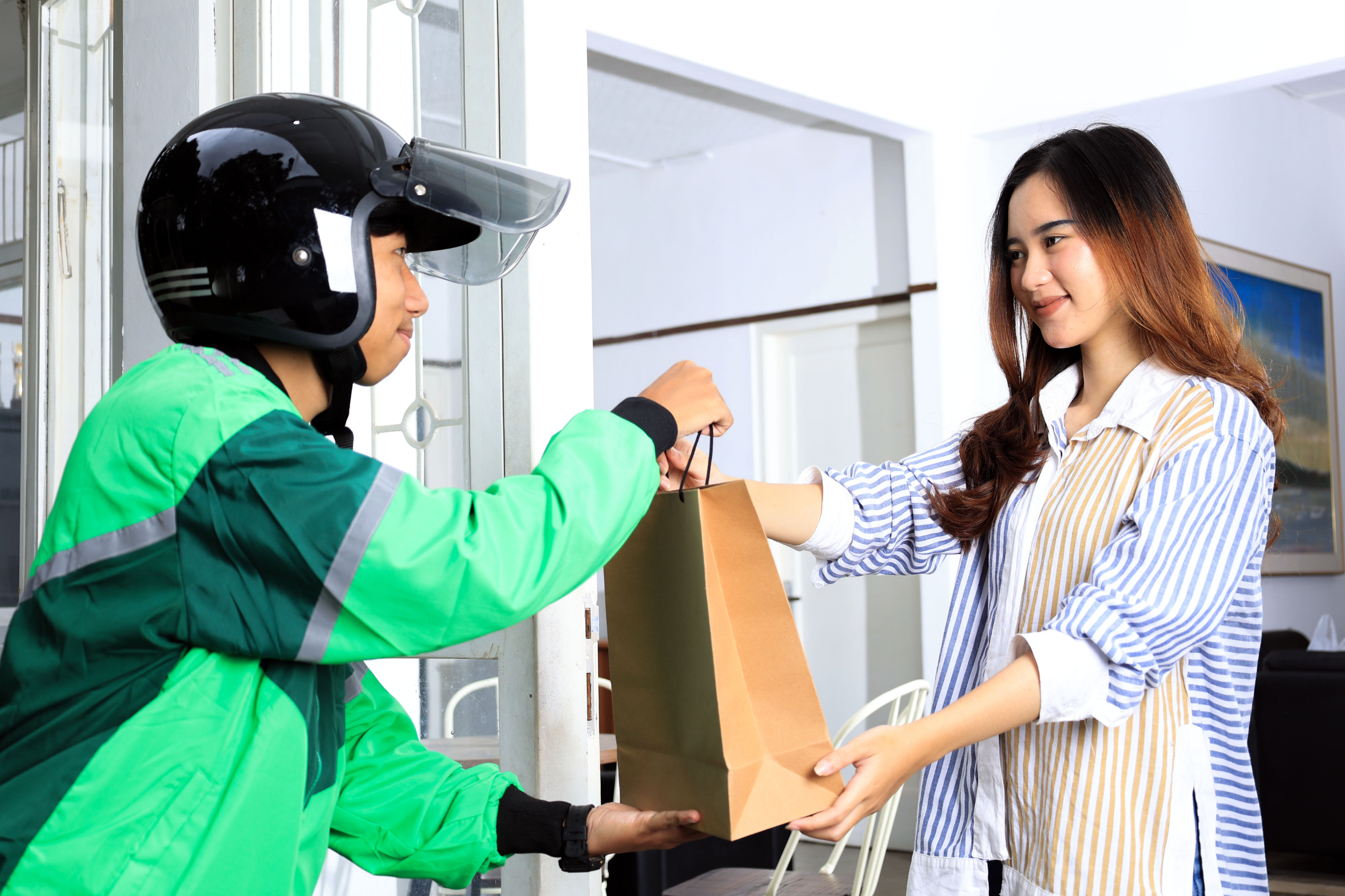 Food delivery driver hands food to customer